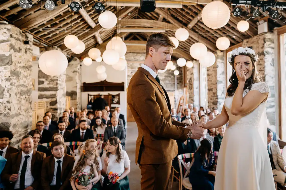 bride sheds a tear in a rustic barn ceremony in Wales